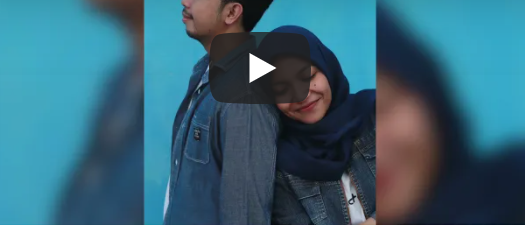 Image of a young girl wearing a hijab and resting her head on the back of a young ethnic boys' shoulder.  