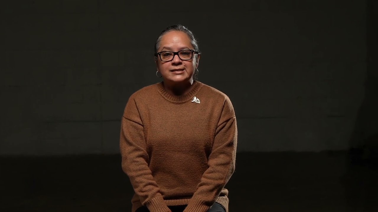 A Latinx woman on a black background