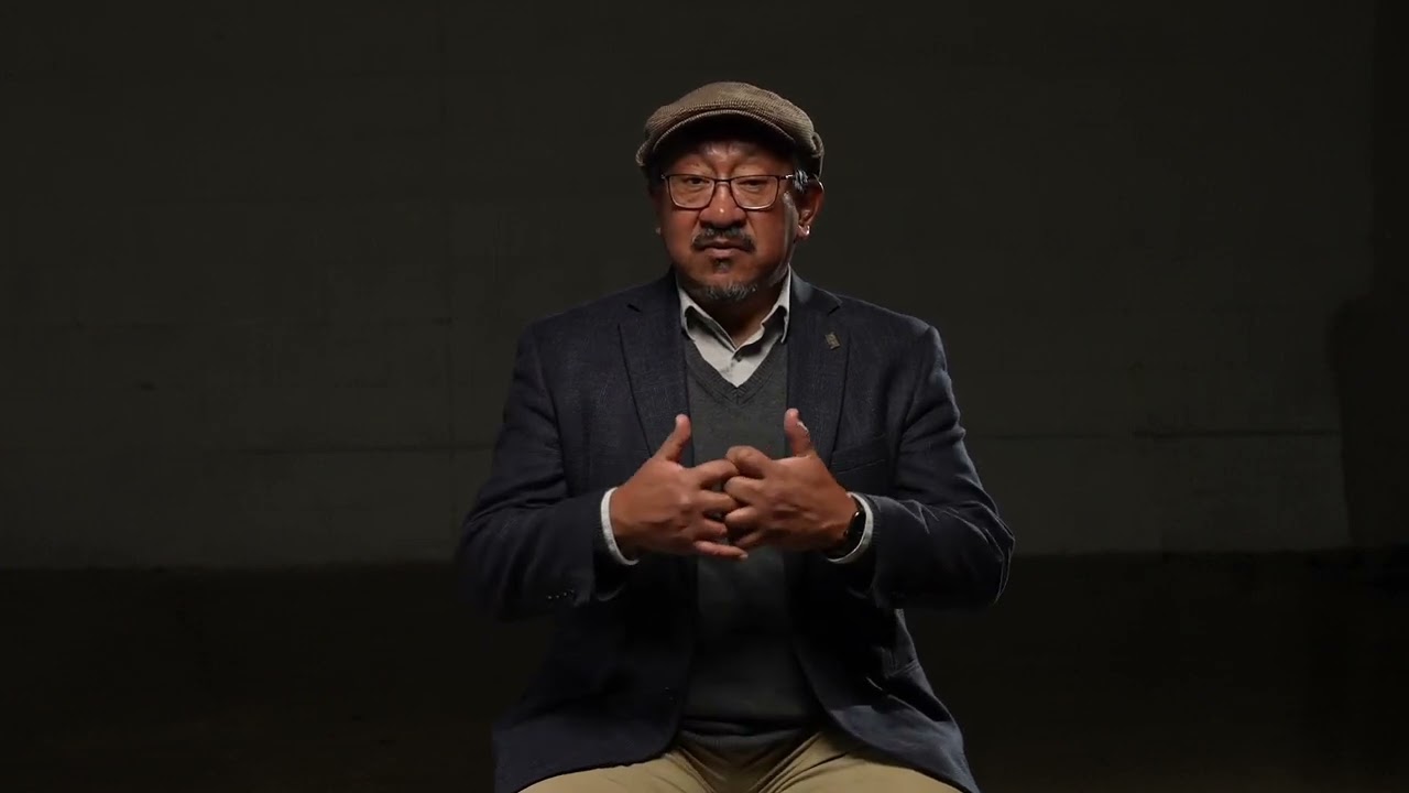 A Latinx man on a black background