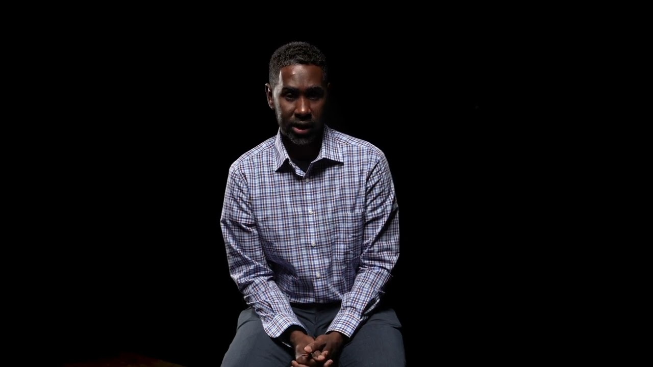 Yahye Ahmed sits on a chair and speaks 