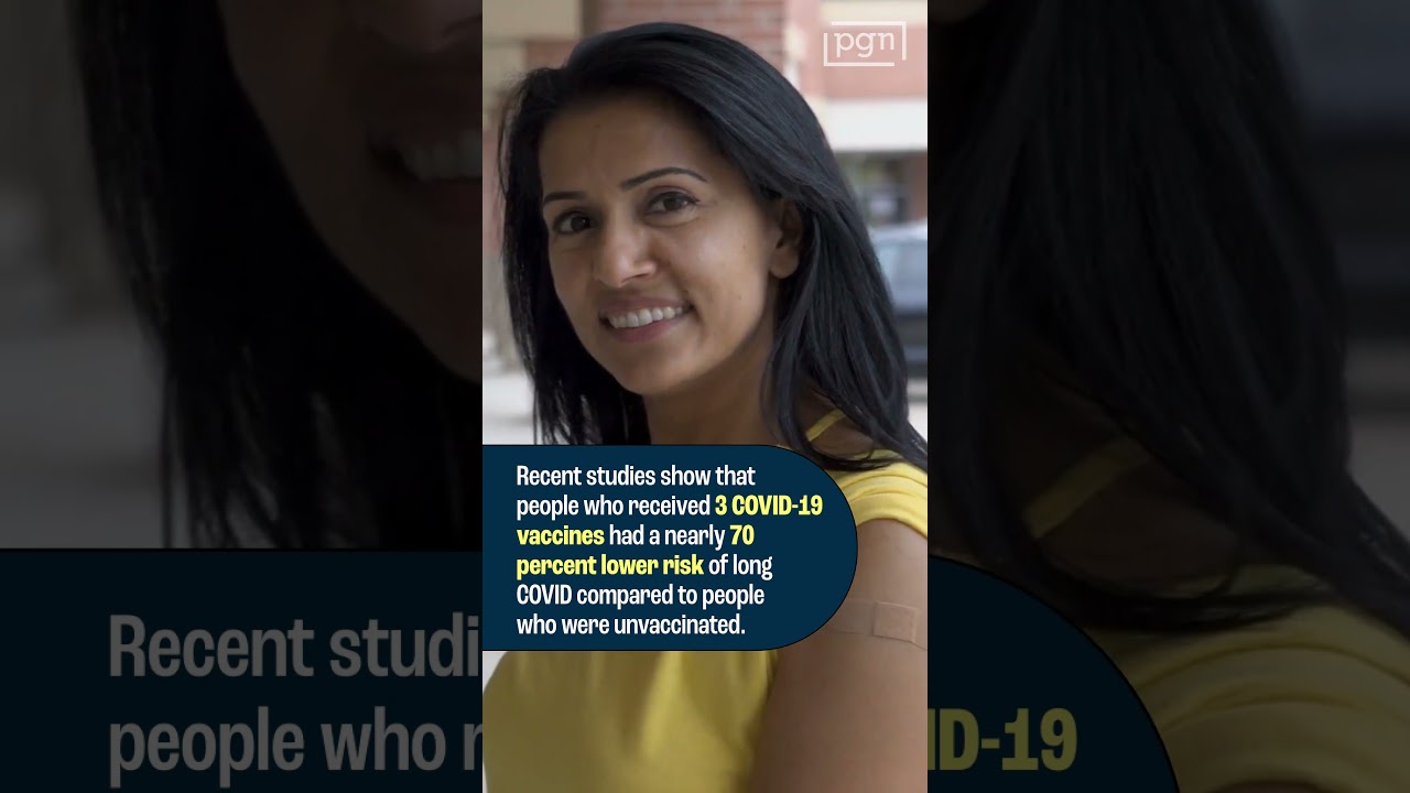 Woman smiles with band-aid on her arm.