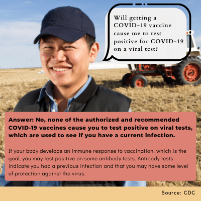asian man smiling in a field with a tractor