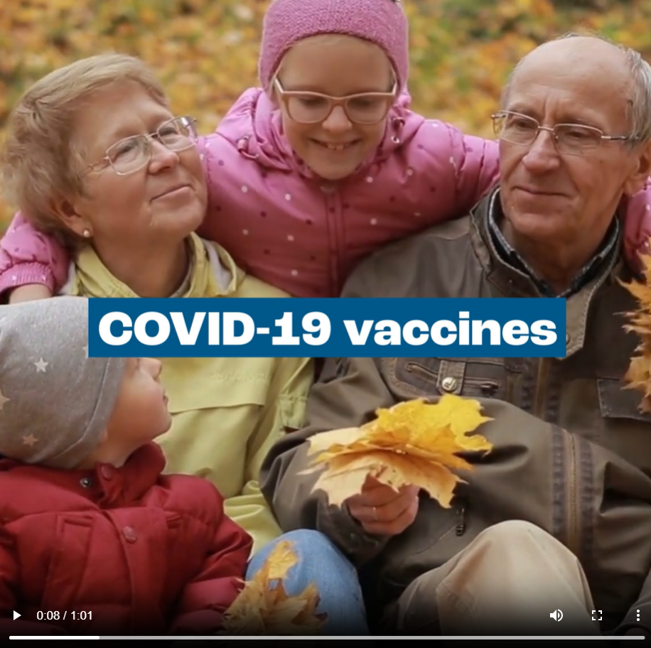 Grandparents sit with their grandchildren outdoors in a fall setting