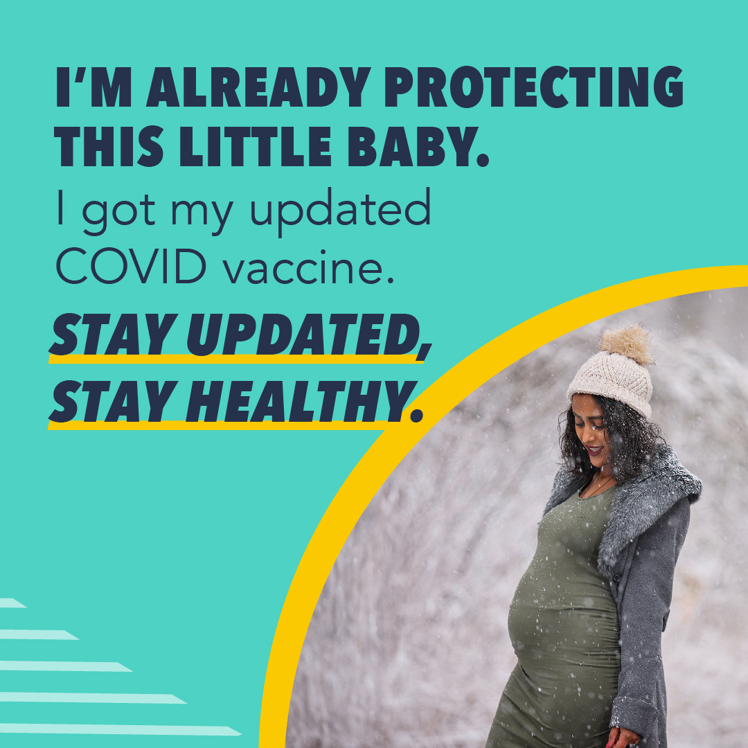 A pregnant woman stands outside on a snowy day and smiles