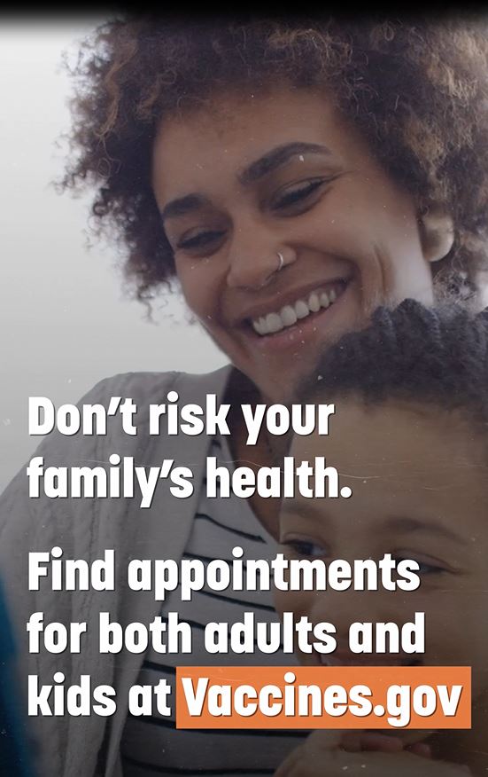 Image of a black woman smiling and holding a young black child