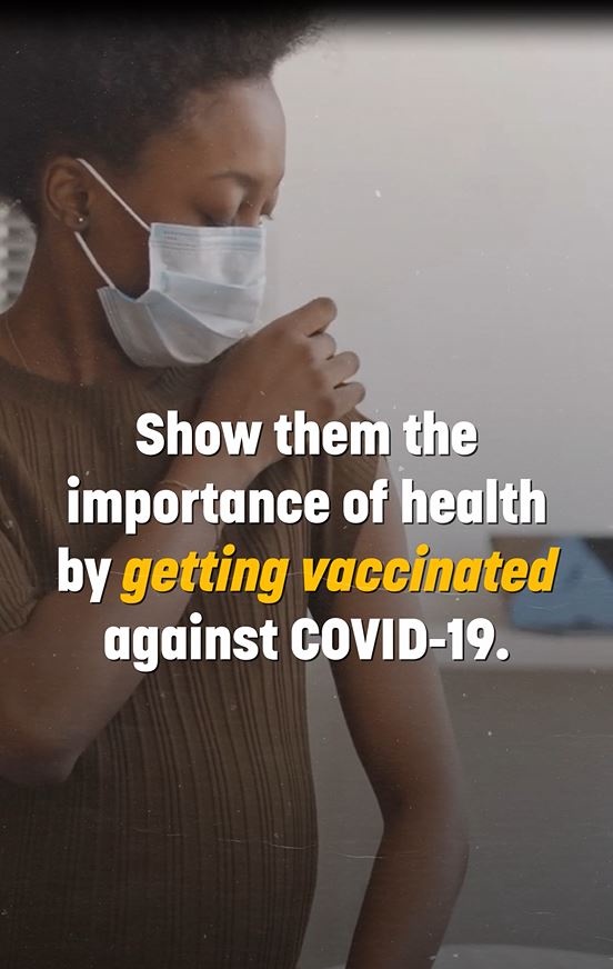 Image of a pregnant black woman wearing a mask and looking at a bandage on her arm