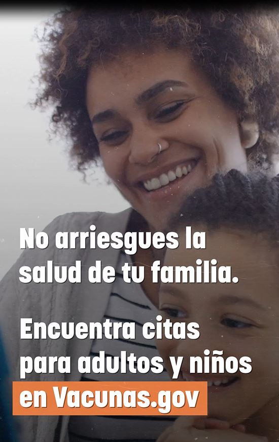 Image of a black woman smiling and holding a young black child