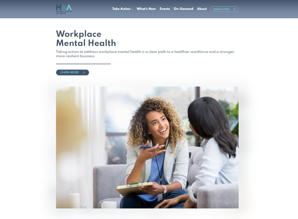 A young Black woman smiles and speaks with another woman.