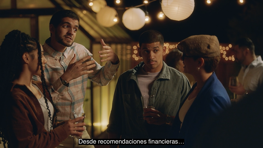 A group of people at a party, with one man speaking enthusiastically. Spanish captions read, "From financial advice...."