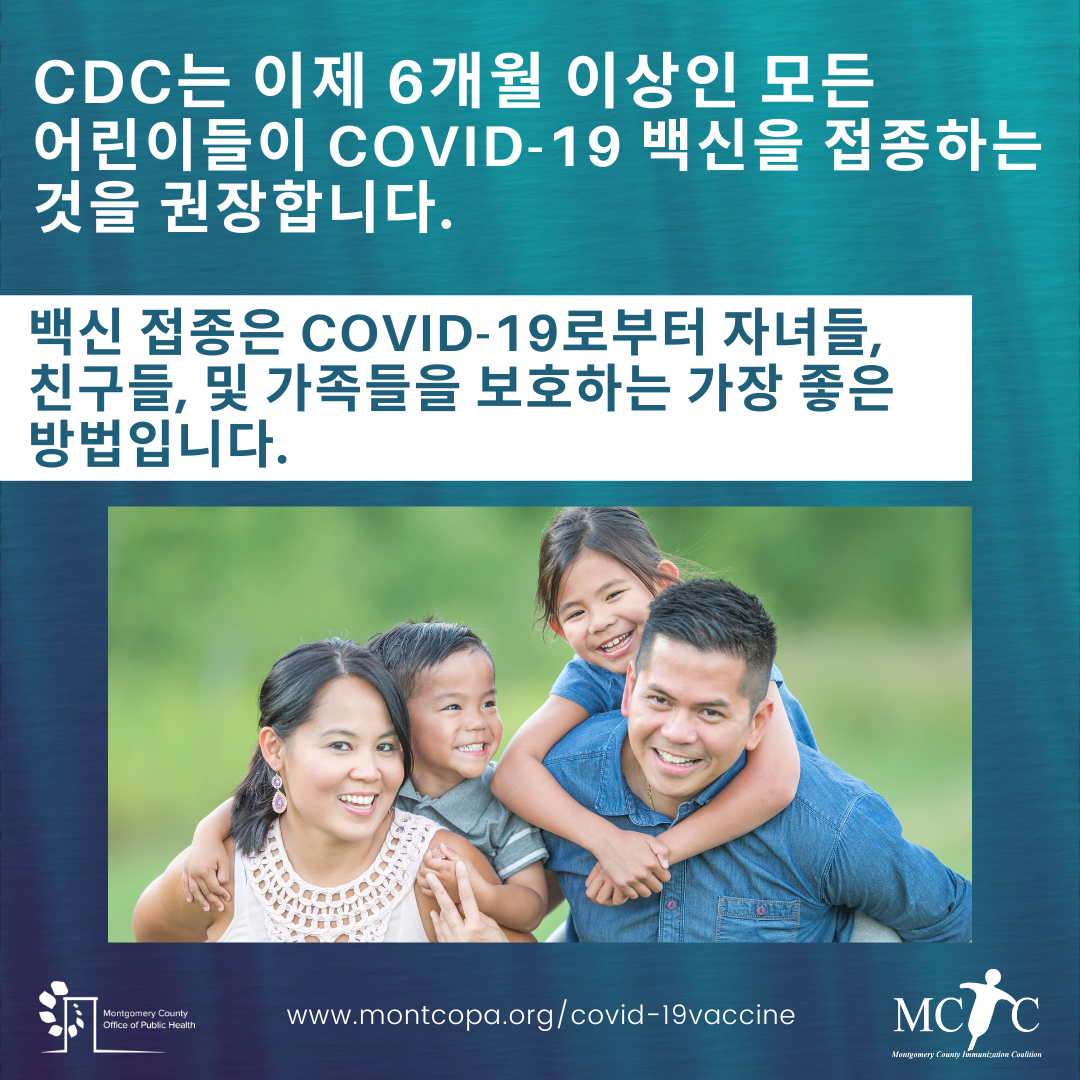 An Asian family with two children smiling in a park.