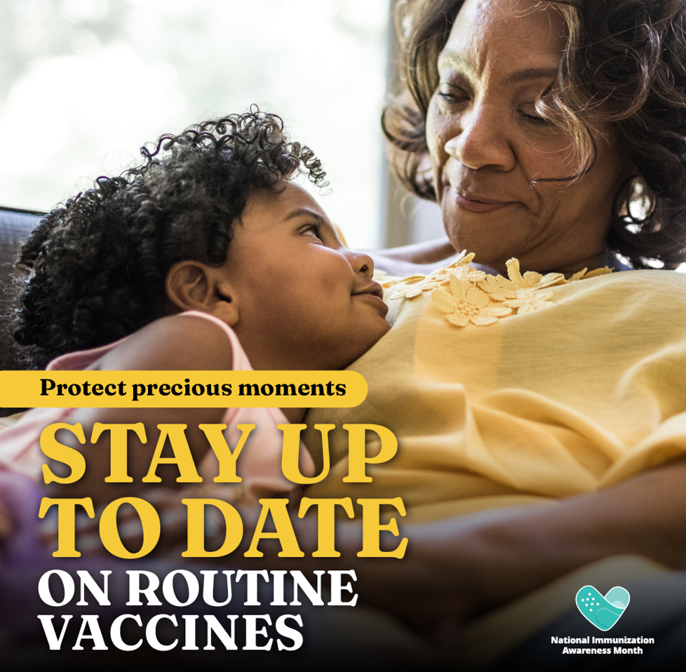 An older Black woman smiles at and cuddles with a young Black child.