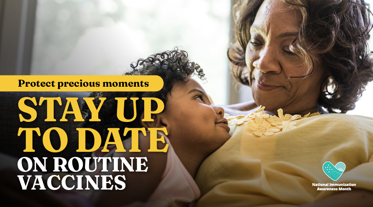 An older Black woman smiles at and cuddles with a young Black child.