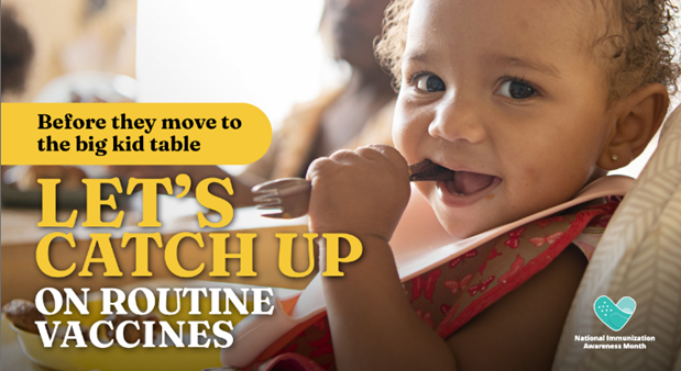 A baby girl with a pink bib around her neck chewing at the end of a fork. 