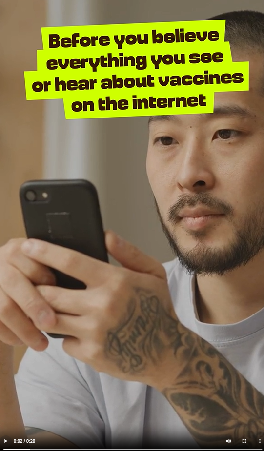 An Asian man looks at his phone