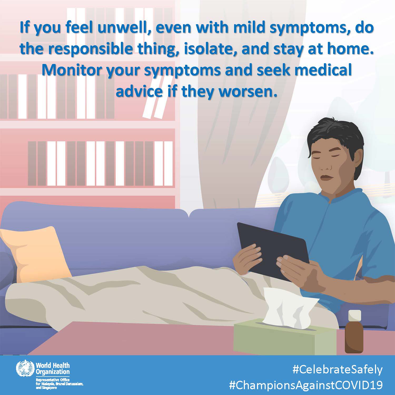 Image shows a south asian man holding an ipad in his room; the man appears to be self-isolating because he is sick