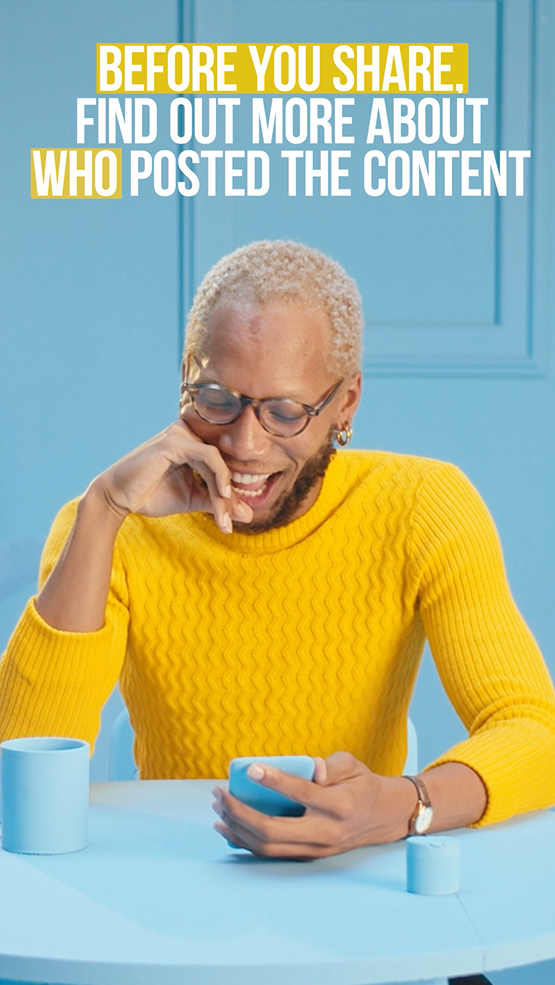 A black person laughs while looking down at their phone.