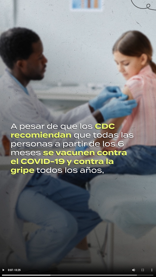 A Black male health care provider puts a band aid on a young girl's shoulder