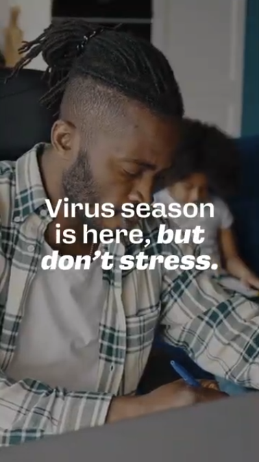 Video rotates through clips of parents working, cooking, ironing clothes, and grocery shopping. Text reads: “Virus season is here, but don’t stress. It’s better to get your flu and COVID-19 vaccines late than not at all.”