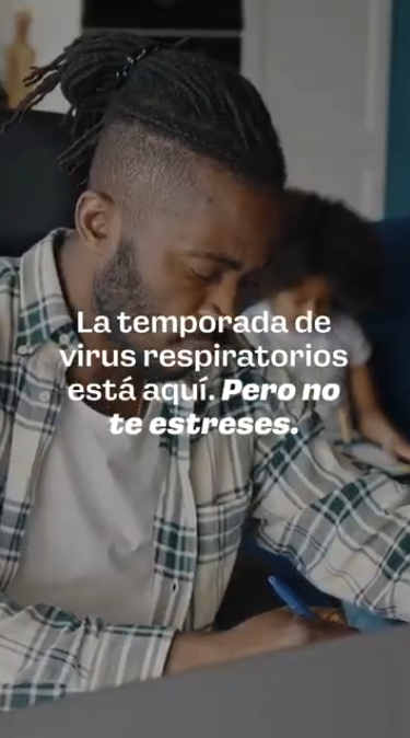 Video rotates through clips of parents working, cooking, ironing clothes, and grocery shopping. Text reads: “Virus season is here, but don’t stress. It’s better to get your flu and COVID-19 vaccines late than not at all.”