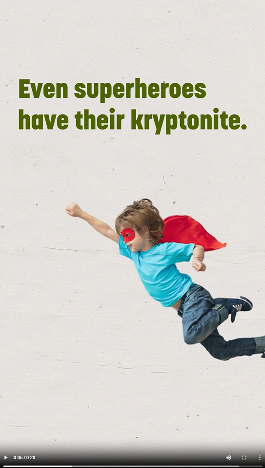 A young boy flies wearing a super hero cape and mask