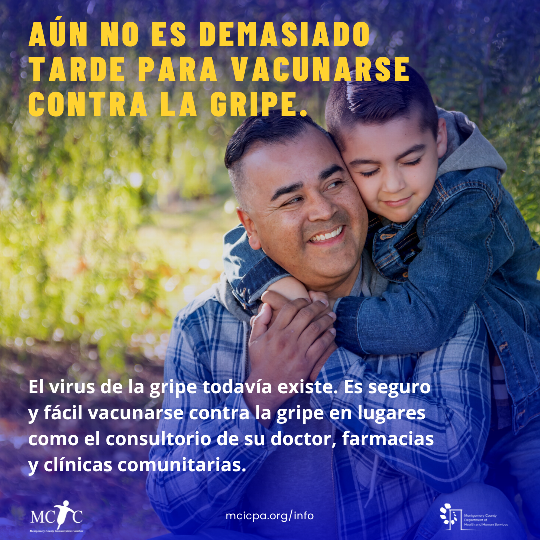 A Hispanic man holds his young son and smiles